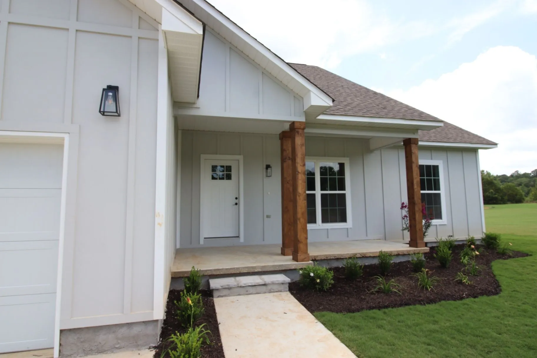 Completed JP2 New Construction front entry with a covered porch and timber posts