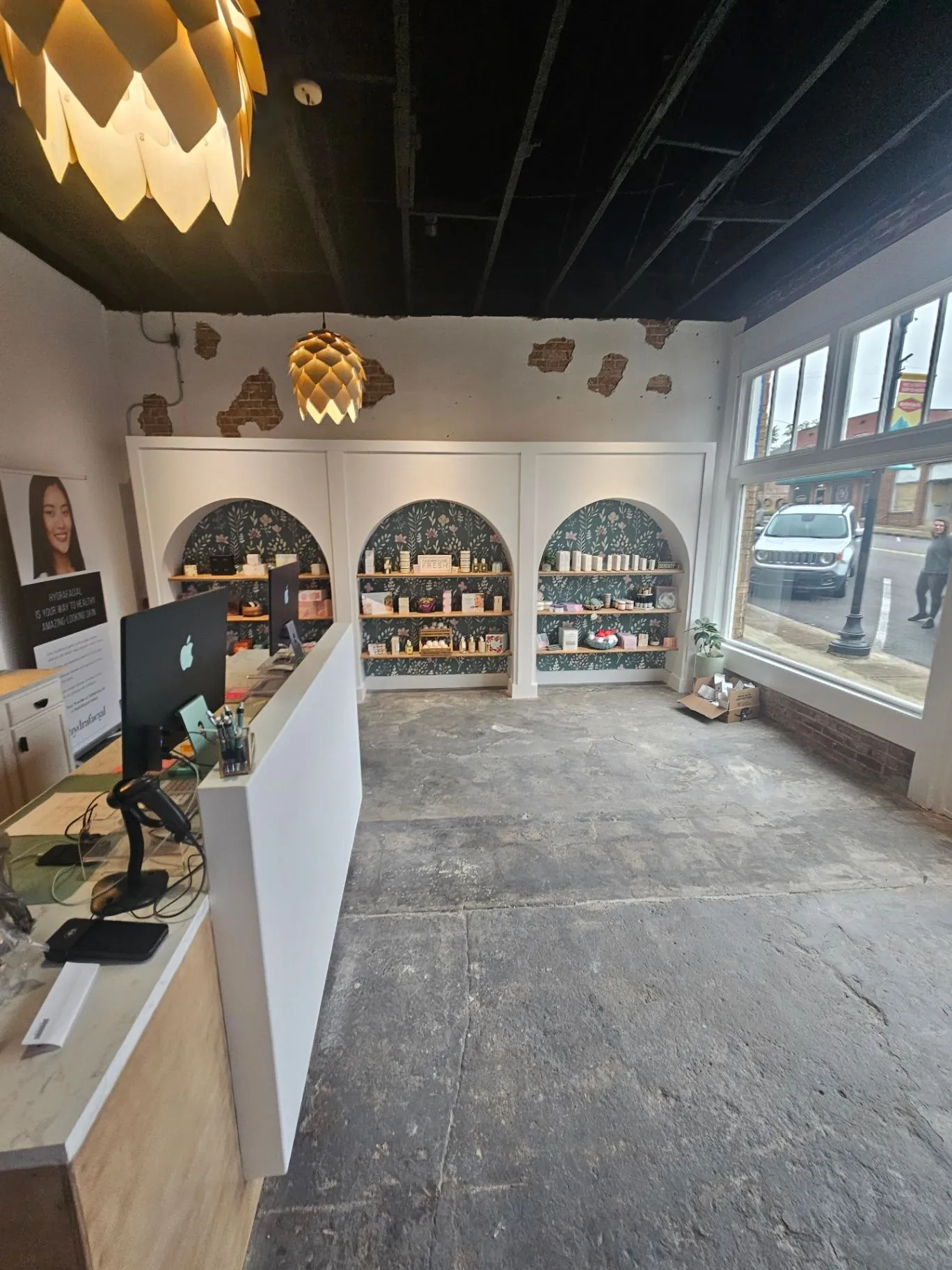 Completed spa interior with a retail display wall, pendant light, and front windows